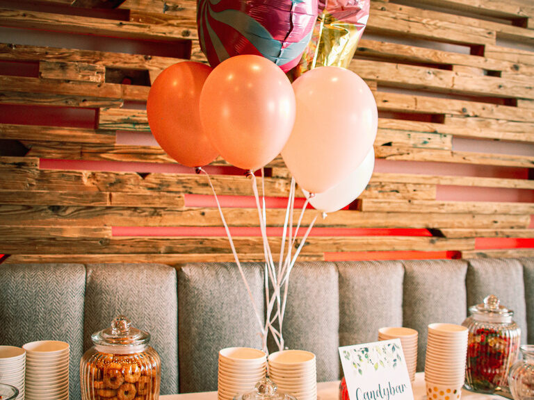 Ein Tisch mit bunten Luftballons als festliche Dekoration bei einer Hochzeit.