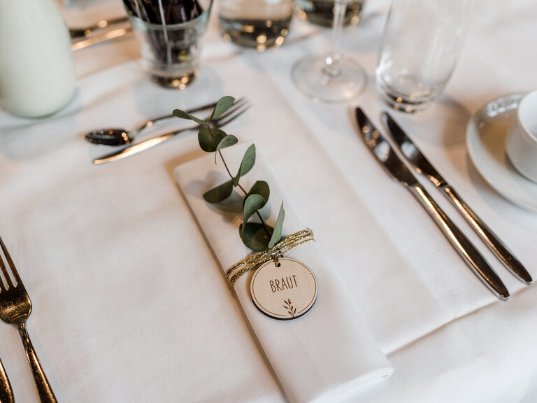 Der Sitzplatz für die Braut auf einer Hochzeit im Toni´s Gasthaus ist gekennzeichnet durch eine Serviette mit einem kleinen Holzanhänger auf dem Braut steht, gekennzeichnet.