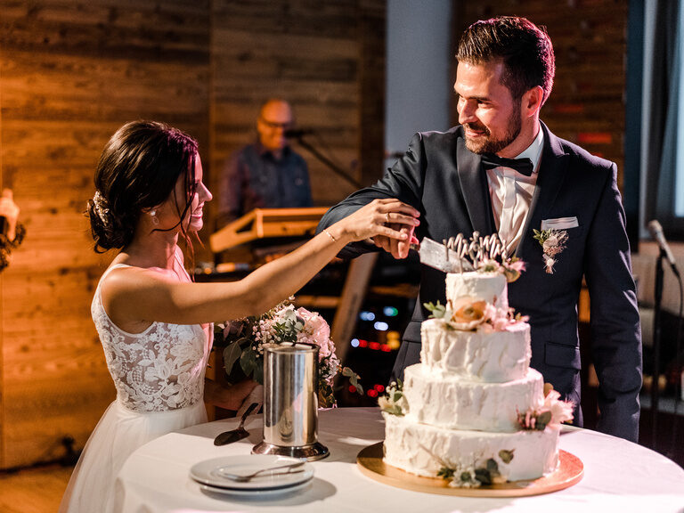 Das Brautpaar schneidet die mehrstöckige Hochzeitstorte im Toni´s by Wenisch an.