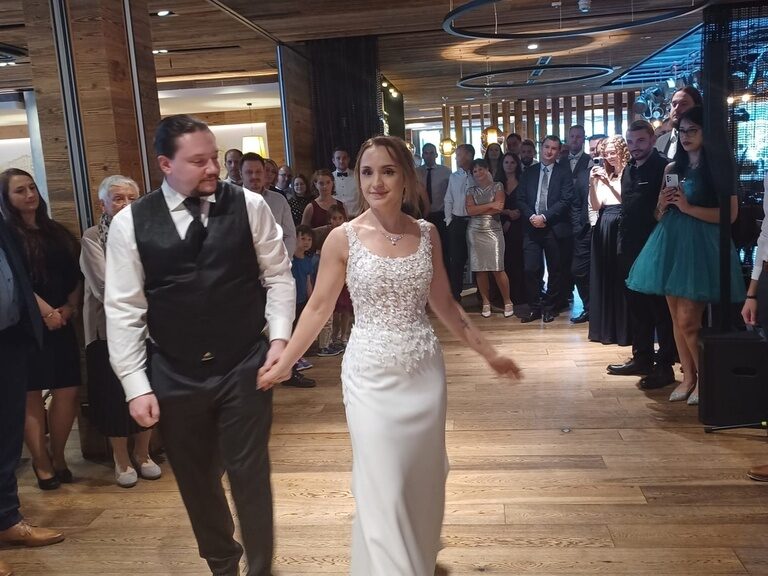 Das Brautpaar spaziert Hand in Hand durch den großen Hochzeitssaal im Tonis.