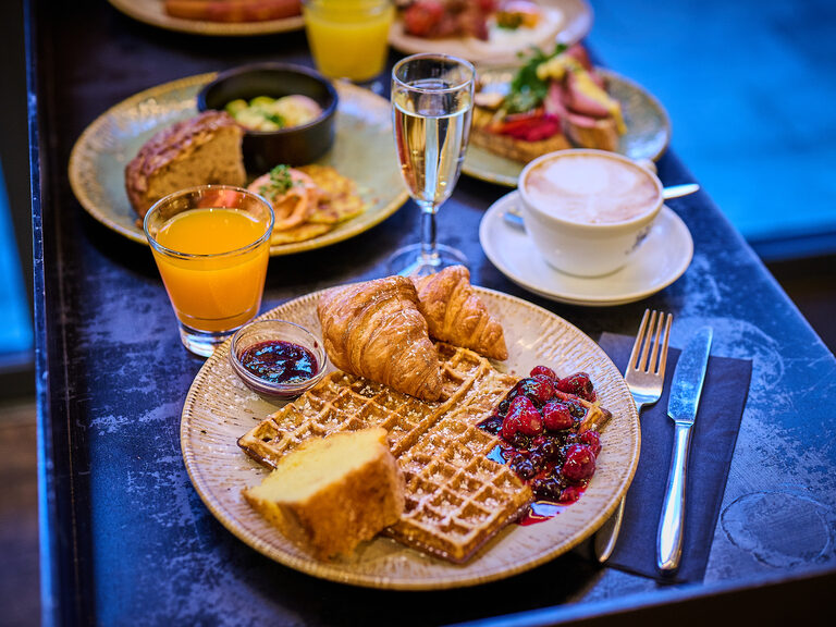 Freie Trauung mit Brautpaar und Traurednerin unter blumengeschmücktem Traubogen
