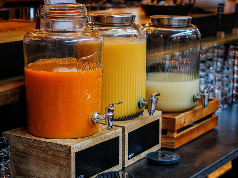 Drei Saftspender mi bunten Fruchtsäften stehen am Frühstücksbuffet im Gasthaus Toni´s in Straubing