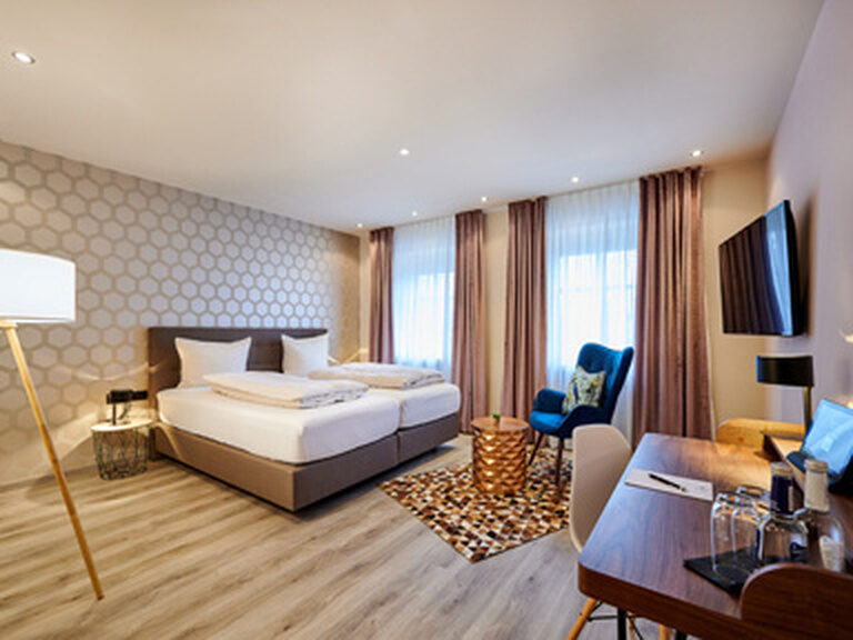 Ein gemütliches Standard-Zimmer mit einem großen Bett und stilvollem Interieur im Genusshotel Wenisch