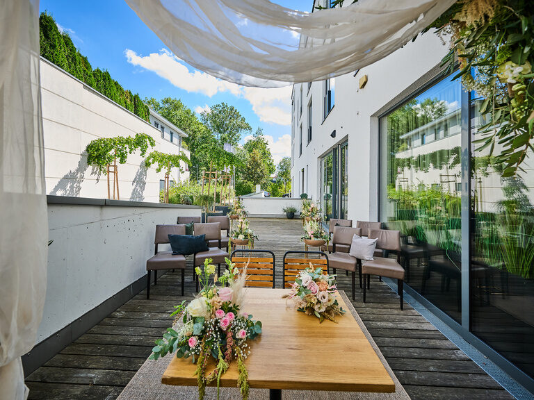 Outdoor-Trauort mit Blumenschmuck und Sitzplätzen für freie Trauung.