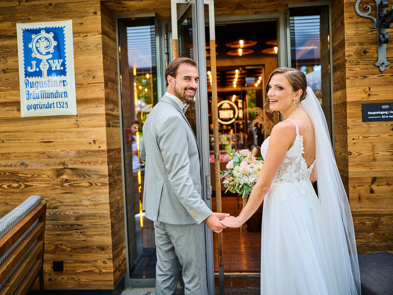 Frisch verheiratetes Paar betritt lächelnd das Restaurant nach der Trauung