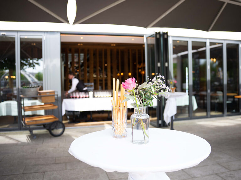Ein eleganter Hochzeitstisch mit weißer Tischdecke in Toni´s Eventlocation in Straubing.