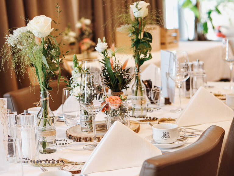Ein elegant gedeckter Tisch im Hochzeitsbankett mit edler Tischdecke und Servietten.