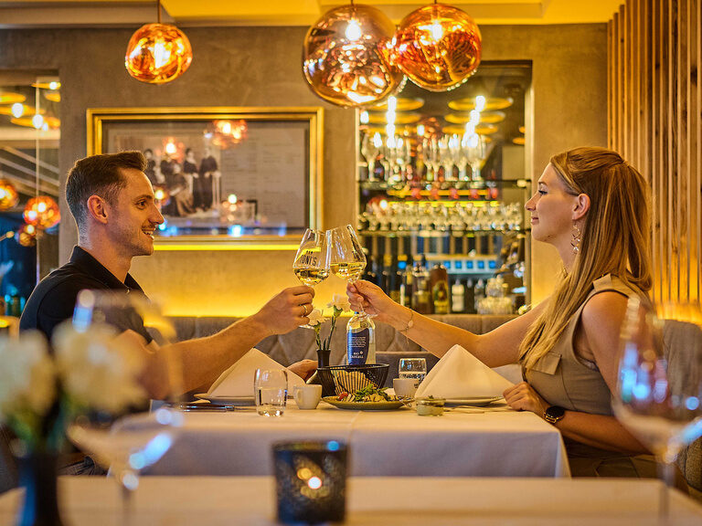 Ein Mann und eine Frau speisen in gemütlicher Atmosphäre bei TONIs by Wenisch.