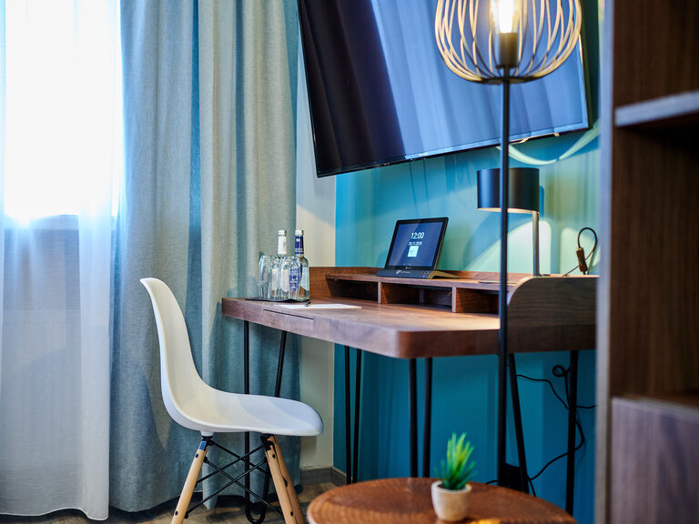 Ein Schreibtisch und ein Stuhl im Standard-Zimmer mit blauen Wänden.