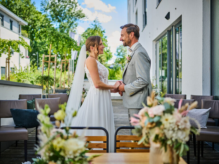 Glückliches Hochzeitspaar blickt sich bei der Zeremonie liebevoll in die Augen
