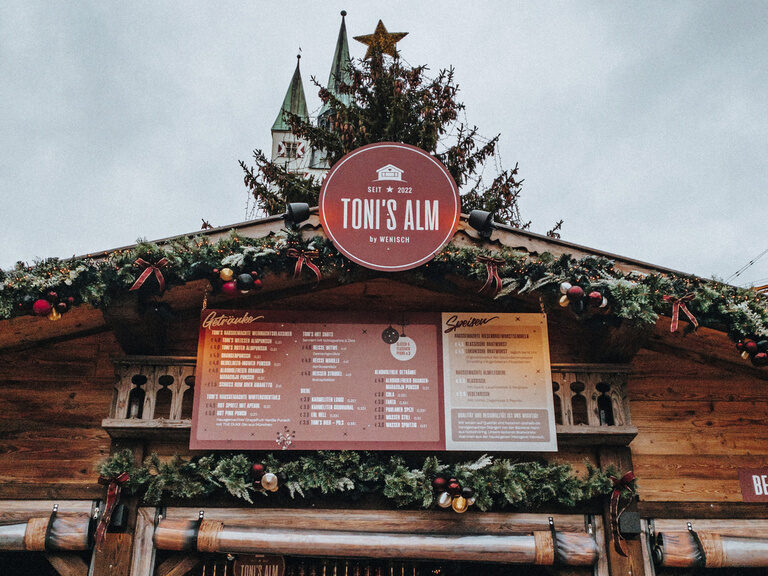 Auf einem Weihnachtsmarkt steht der Stand des Toni´s Gasthaus bereit.